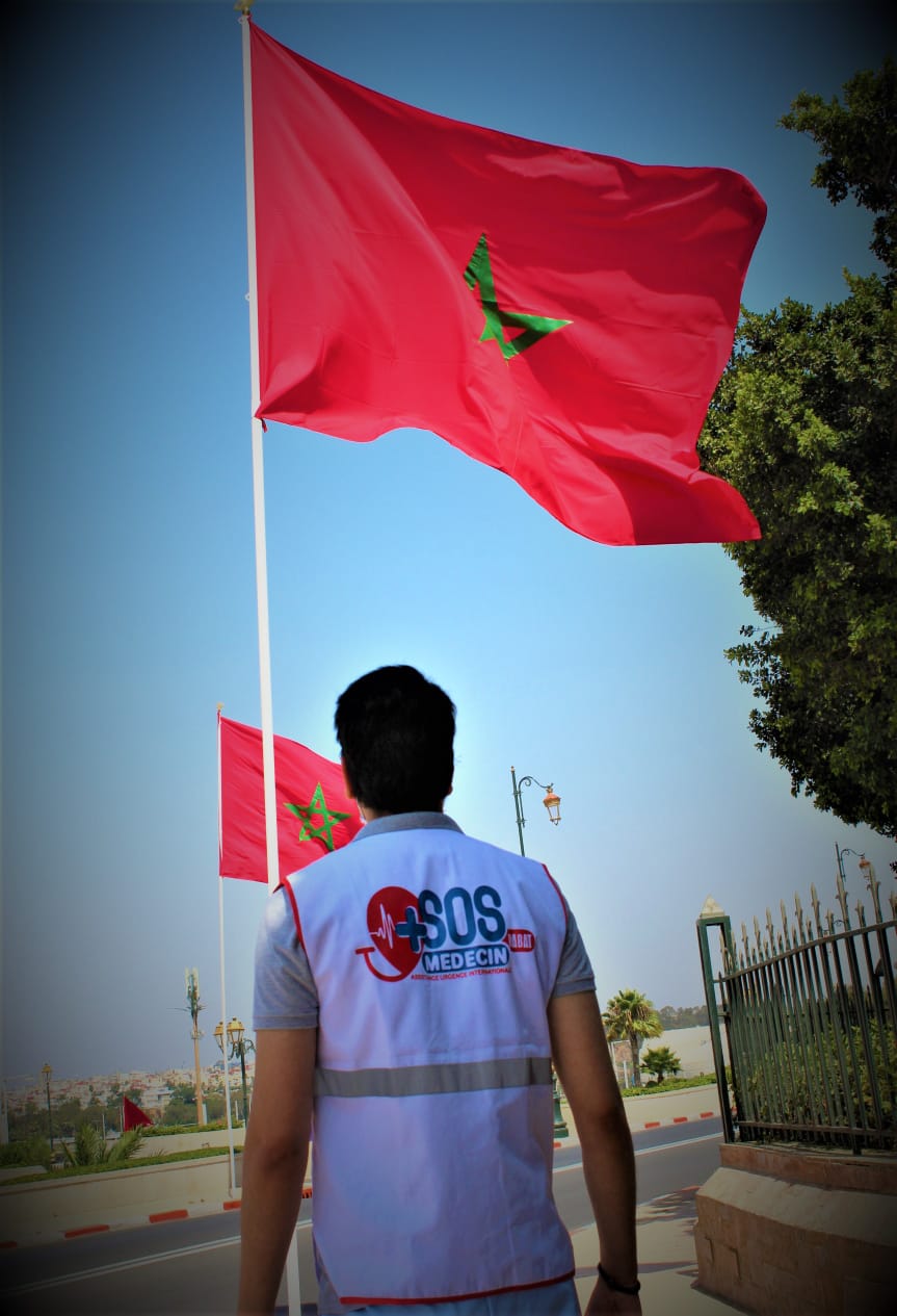 medecin de la societe SOS MEDECIN RABAT devant drapeau Maroc